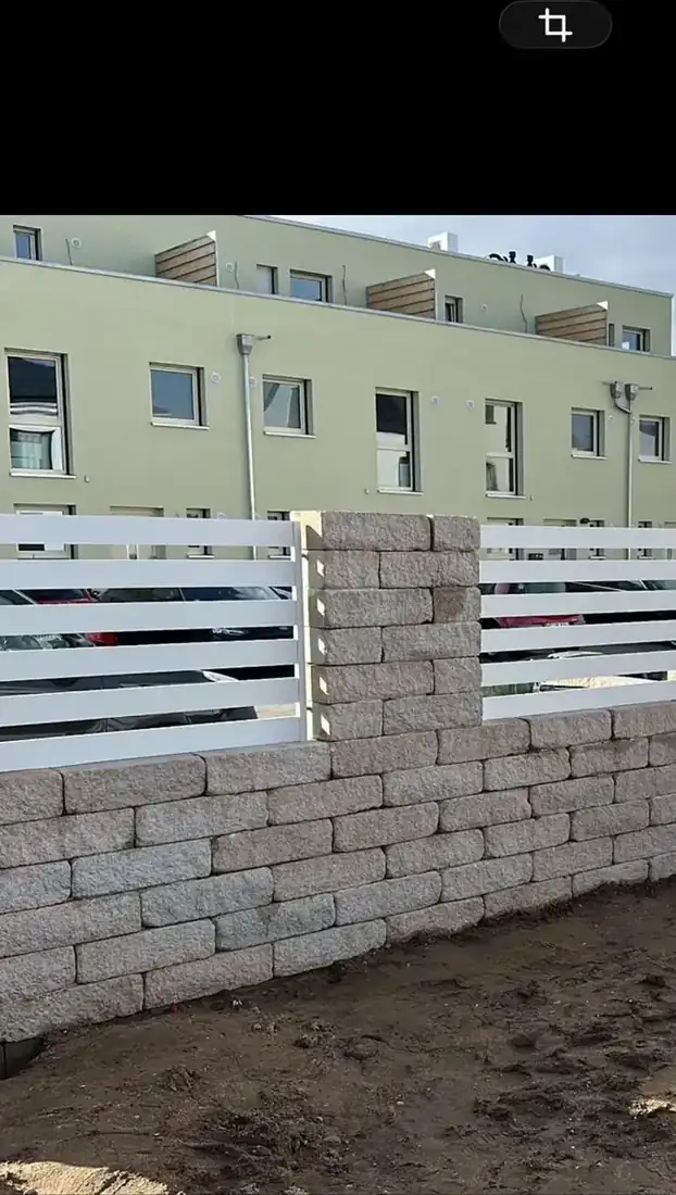 Weißer Zaun auf einer Mauerkrone nach dem Aufbau